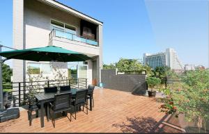 eine Terrasse mit Tisch und Stühlen und einem Sonnenschirm in der Unterkunft Liu Yuan Green Villa in Taitung