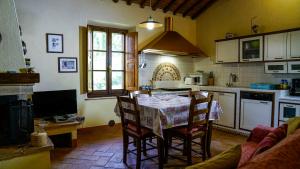 a kitchen with a table and chairs in a kitchen at La Casa Del Fattore in Monteriggioni