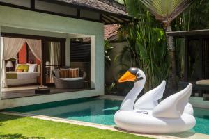 un cisne flotando en una piscina al lado de un complejo en Villa Air Bali Boutique Resort and Spa, en Seminyak