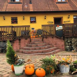 Ein Haufen Kürbisse sitzt vor einem Haus. in der Unterkunft Penzion Hrádecký Dvůr in Pilsen