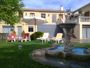 バルティエラにあるCasa Rural Sancho el Fuerteの椅子と傘が置かれた庭の噴水