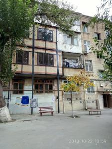 dos bancos sentados frente a un edificio en Sweet Apartment en Bakú