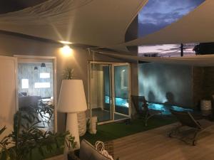 - un salon avec vue sur la piscine dans l'établissement L'Olivine, à Saint-Pierre