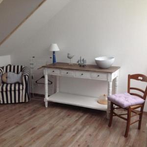Zimmer mit einem Tisch, einer Schüssel und einem Stuhl in der Unterkunft Villa des Sarcelles in Le Crotoy