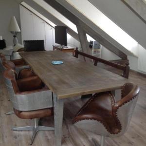 a wooden table in a living room with chairs at Villa des Sarcelles in Le Crotoy