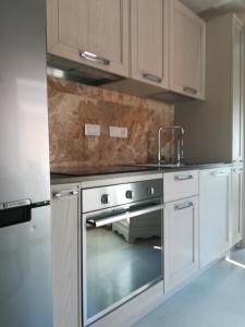 a kitchen with a stainless steel oven with a sink at La Casetta in Tellaro