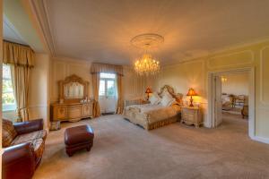 um quarto grande com uma cama e um lustre em Saltcote Place em Rye