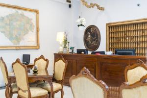 a room with a desk and a table and chairs at Hotel Bologna in Prague