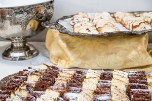 a table with a tray ofbrownies and a plate of desserts at Hotel Bologna in Prague