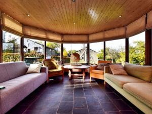 uma sala de estar com sofás e uma mesa em Rustic house with sunroom em Petit-Thier