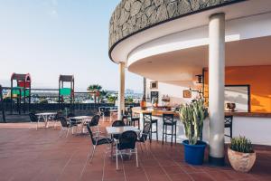 ein Restaurant mit Tischen und Stühlen auf einer Terrasse in der Unterkunft Dreamplace Bocayna Village in Playa Blanca