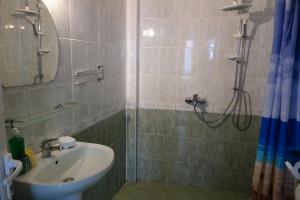 a bathroom with a sink and a shower with a mirror at Aquamarine in Sozopol