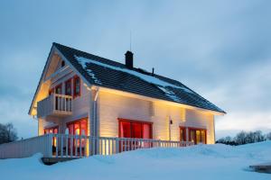 una casa con puertas rojas en la nieve en Vasekoja Holiday Center, en Vahtseliina