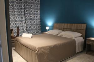 una camera da letto con un letto grande con una parete blu di Harmony Rooms a Catania