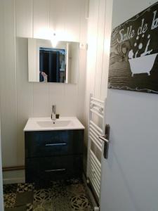 uma casa de banho com um lavatório e um espelho em L'étoile du Nord SUPERDEVOLUY em Le Dévoluy