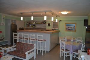 a restaurant with a bar and a table and chairs at Stella Hotel Apartments in Fiskardo