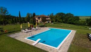 a swimming pool in a yard with chairs and a house at La Casa Del Fattore in Monteriggioni