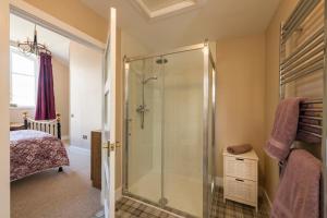 a bathroom with a shower with a glass door at Evelix, The Old School House in Muir of Ord +5 photos