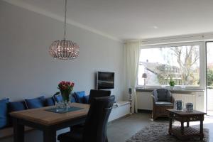 ein Wohnzimmer mit einem blauen Sofa und einem Tisch in der Unterkunft Ferienwohnung Urlaubsflair Scharbeutz in Scharbeutz
