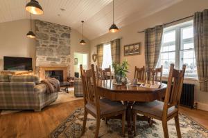 a living room with a table and chairs and a couch at Evelix, The Old School House in Muir of Ord