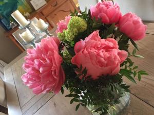 un bouquet de fleurs roses dans un vase sur une table dans l'établissement Les Aiguières en Provence, à Suze-la-Rousse