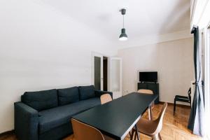 een woonkamer met een blauwe bank en een tafel bij Americano in Athene