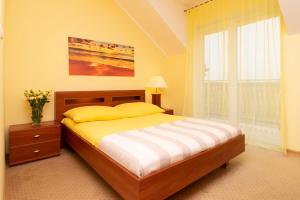 a bedroom with a bed and a large window at Pensjonat Marynarski - Apartamenty in Darlowko