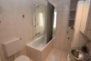 ein Badezimmer mit einer Badewanne, einem WC und einem Waschbecken in der Unterkunft AB Apartment Objekt 114 in Fellbach