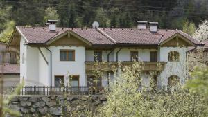 ein großes weißes Haus mit einer Steinmauer in der Unterkunft Haus Annemarie Schiestl in Zell am Ziller