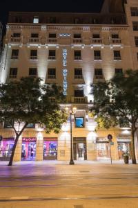 un edificio de noche con árboles delante en Hotel Oriente, en Zaragoza
