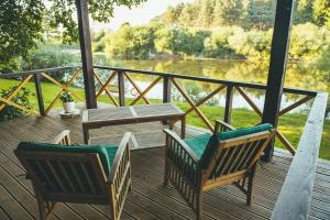 two chairs and a table on a deck with a view at Pamario Krašto Sodyba in Grumbliai +28 photos