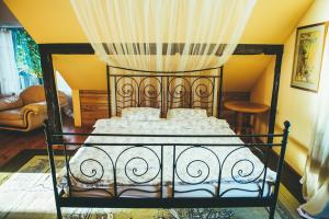 a bedroom with a bed with a canopy at Pamario Krašto Sodyba in Grumbliai