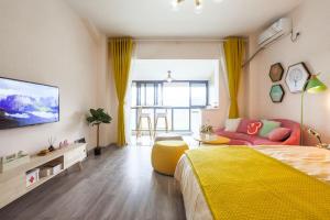 a bedroom with a yellow bed and a couch at Chengdu Dujiangyan·DuJiangYan· Locals Apartment 00171880 in Zhongxing