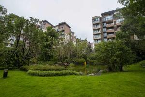 a park in a city with tall buildings at Chengdu Dujiangyan·DuJiangYan· Locals Apartment 00171880 in Zhongxing
