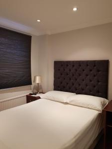 a bedroom with a large white bed and a window at Blagrave Rooms in Reading