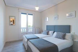 a bedroom with two beds and a window at Atlantic - Iberorent Apartments in San Sebastián