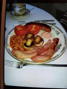 une plaque de nourriture avec des œufs, des saucisses, des haricots et des tomates dans l'établissement Bron Orme Private Hotel, à Llandudno