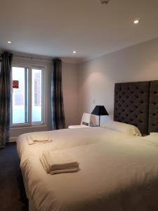 Un dormitorio con una gran cama blanca y una ventana en Blagrave Rooms en Reading