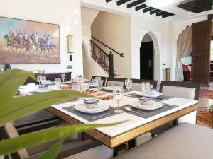 a dining room with a table with plates and glasses at VILLA ILYANA in Marrakesh