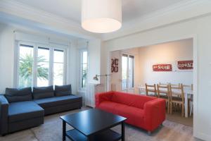 a living room with a couch and a red chair at Atlantic - Iberorent Apartments in San Sebastián