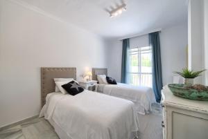 biała sypialnia z dwoma łóżkami i oknem w obiekcie Senorio de Gonzaga Great 2 bedroom apartment with a lovely community pool in the heart of Nueva Andalucia w Marbelli +24 zdjęcia