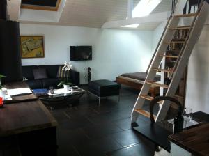 a living room with a staircase and a couch at Lodge & lake in Buchillon