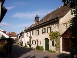 a white building with a green door on a street at Lodge & lake in Buchillon