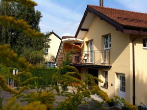 a house with a balcony on the side of it at Lodge & lake in Buchillon