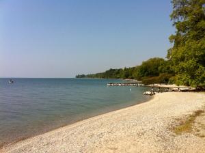 a beach with a large body of water at Lodge & lake in Buchillon +2 photos