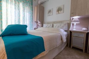 una camera con un grande letto e una finestra di Moriel Seaside Homes Suites a Elia
