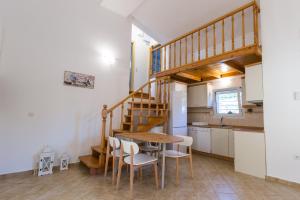 a kitchen and dining room with a wooden table and chairs at Moriel Seaside Homes Suites in Elia
