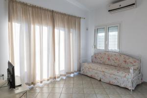 un soggiorno con divano e ampie finestre di Moriel Seaside Homes Suites a Elia