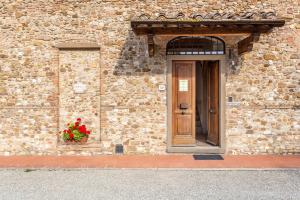 a building with a door and a flower pot on it at Fattoria Querceto in Tavarnelle in Val di Pesa