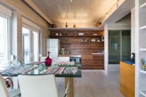 una cucina con tavolo in vetro e vaso di Designer's Apartment a Perea